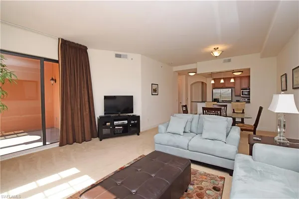 a living room with furniture and view of kitchen