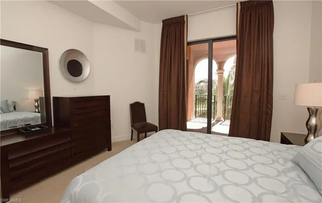 a spacious bedroom with a bed and a lamp