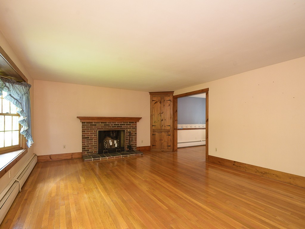 19 8 Lots Road Sutton, MA 01590 - Photo 3 of 30 an empty room with wooden floor and fireplace
