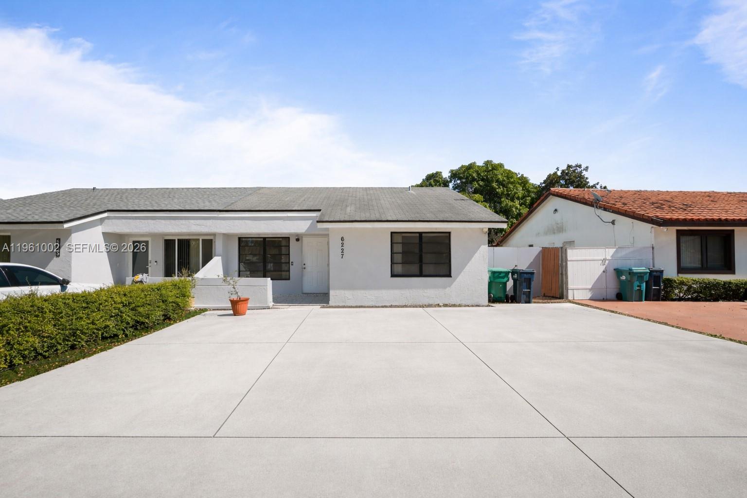 6227 Southwest 135th Avenue Miami, FL 33183 - Photo 1 of 24 a front view of house with yard and trees in the background