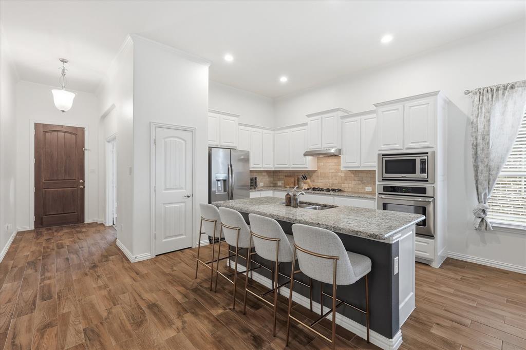 215 Equestrian Road Hickory Creek, TX 75065 - Photo 9 of 36 a kitchen with stainless steel appliances granite countertop a stove refrigerator and cabinets