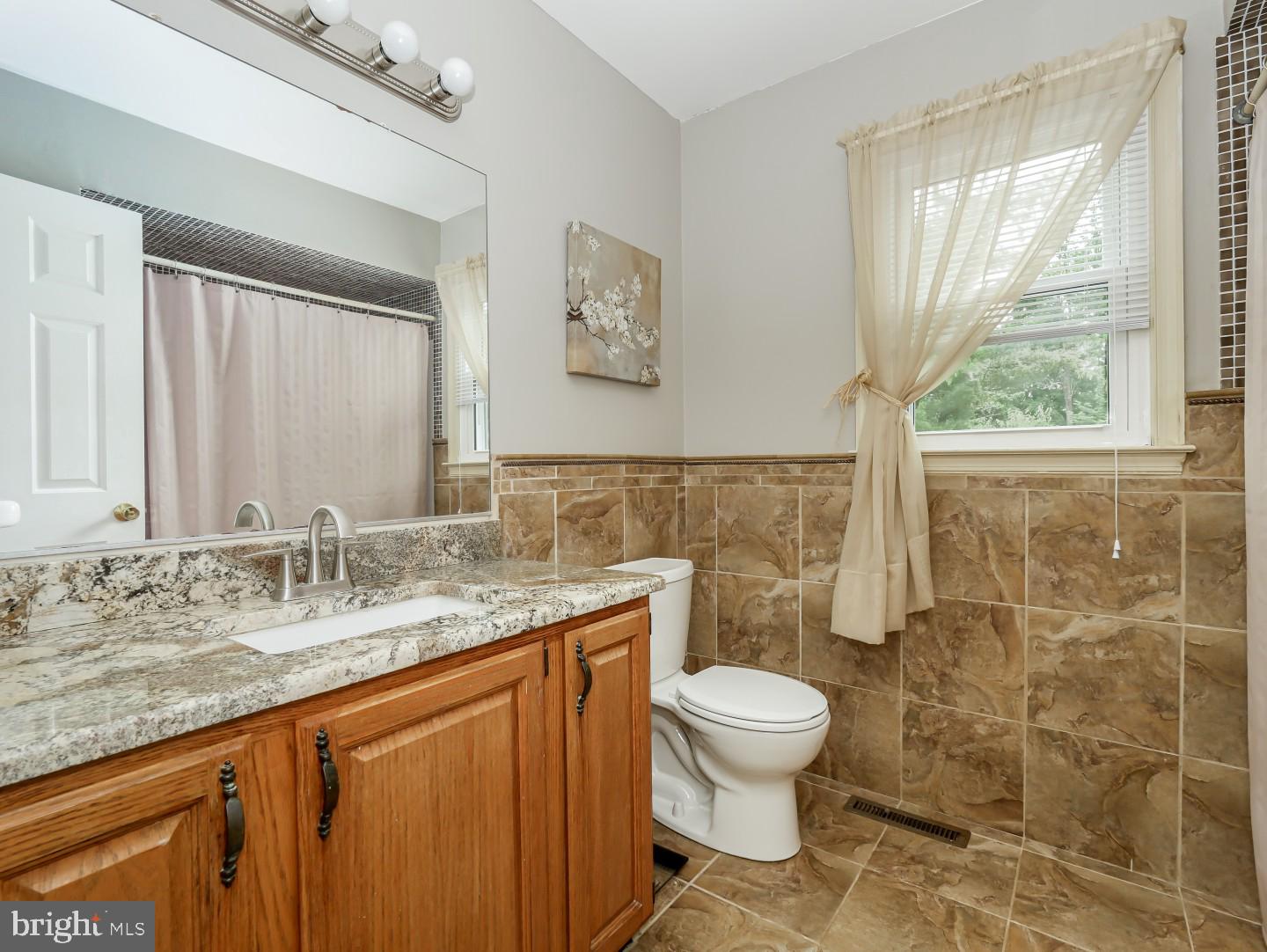281 Cliveden Drive Newtown, PA 18940 - Photo 31 of 35 a bathroom with a granite countertop sink a toilet and a shower