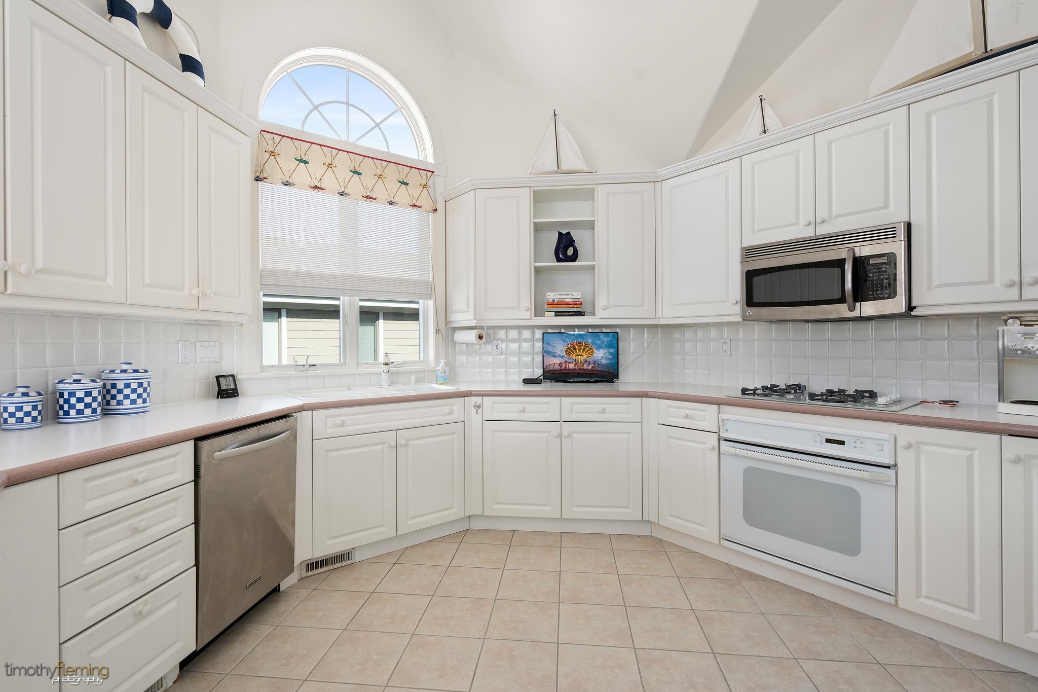 13 12th Street Avalon, NJ 08202 - Photo 3 of 24 a kitchen with cabinets appliances a sink and a window