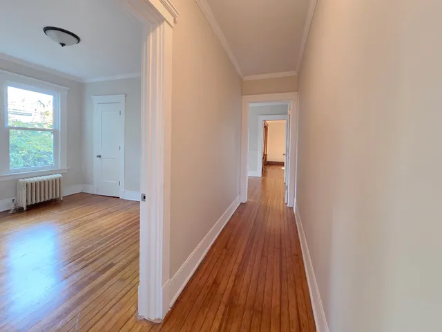 a view of a room with wooden floor and a window