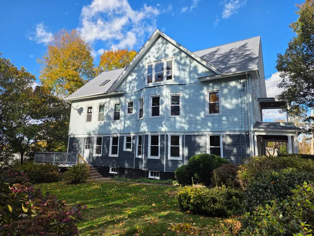 a view of a big house with a big yard and potted plants