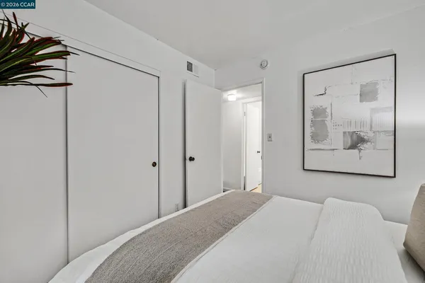 a bedroom with a bed and a painting on the wall