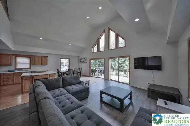 a living room with furniture a flat screen tv and large window