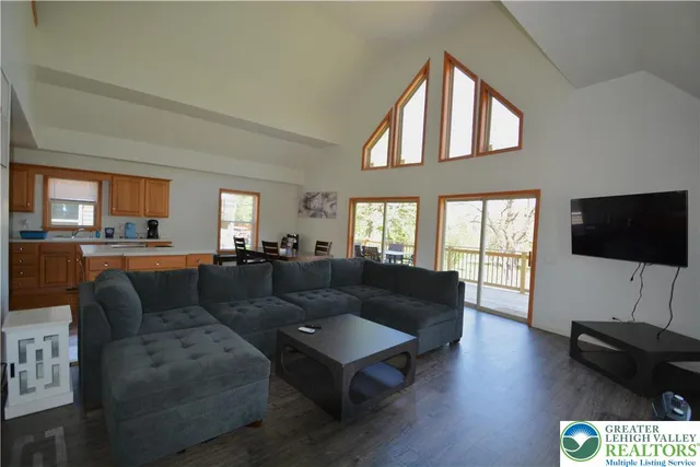 a living room with furniture flat screen tv and wooden floor