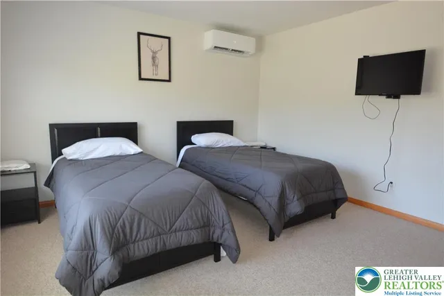 a bedroom with two beds and a flat screen tv