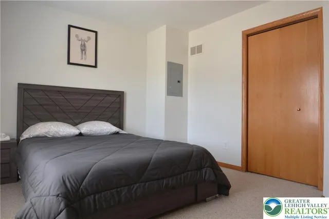 a bedroom with a bed and painting on the wall