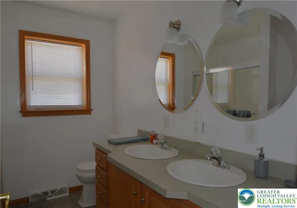 a bathroom with a toilet a sink and mirror
