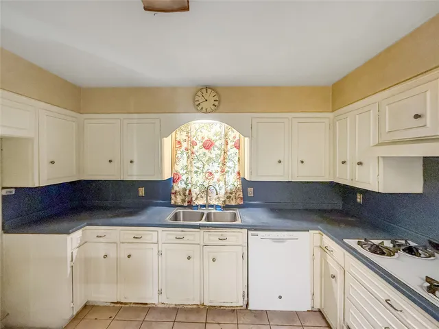 a kitchen with granite countertop white cabinets and white appliances