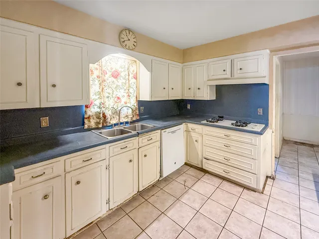 a kitchen with granite countertop white cabinets and white appliances