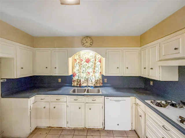 a kitchen with granite countertop white cabinets and white appliances