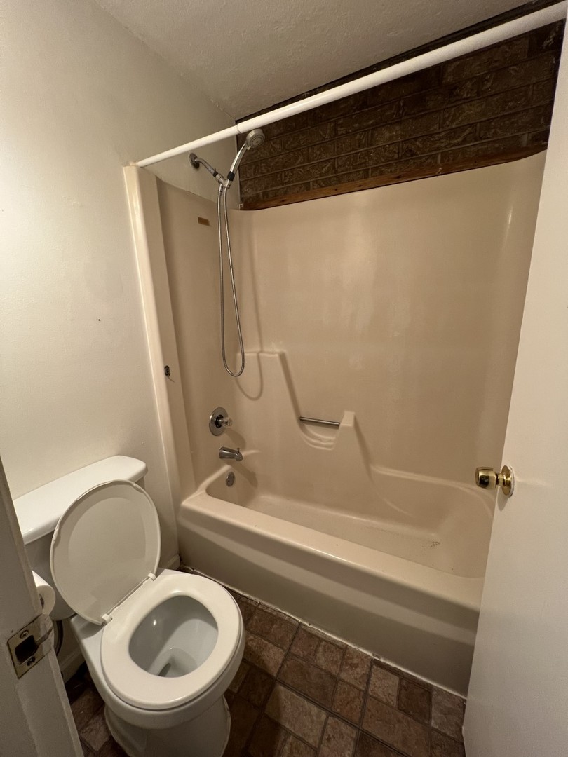 410 Kenneth Circle Elgin, IL 60120 - Photo 12 of 15 a bathroom with a toilet and a shower