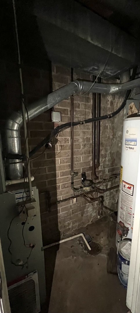 410 Kenneth Circle Elgin, IL 60120 - Photo 7 of 15 a storage room with water heater and racks