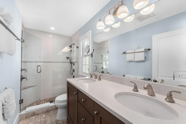 a bathroom with a sink a toilet and shower