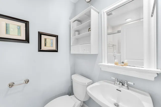 a bathroom with a toilet a sink and mirror