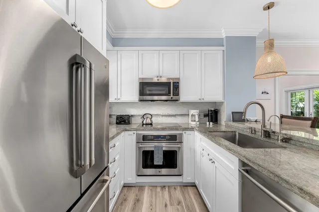 a kitchen with granite countertop a stove top oven a sink and a microwave