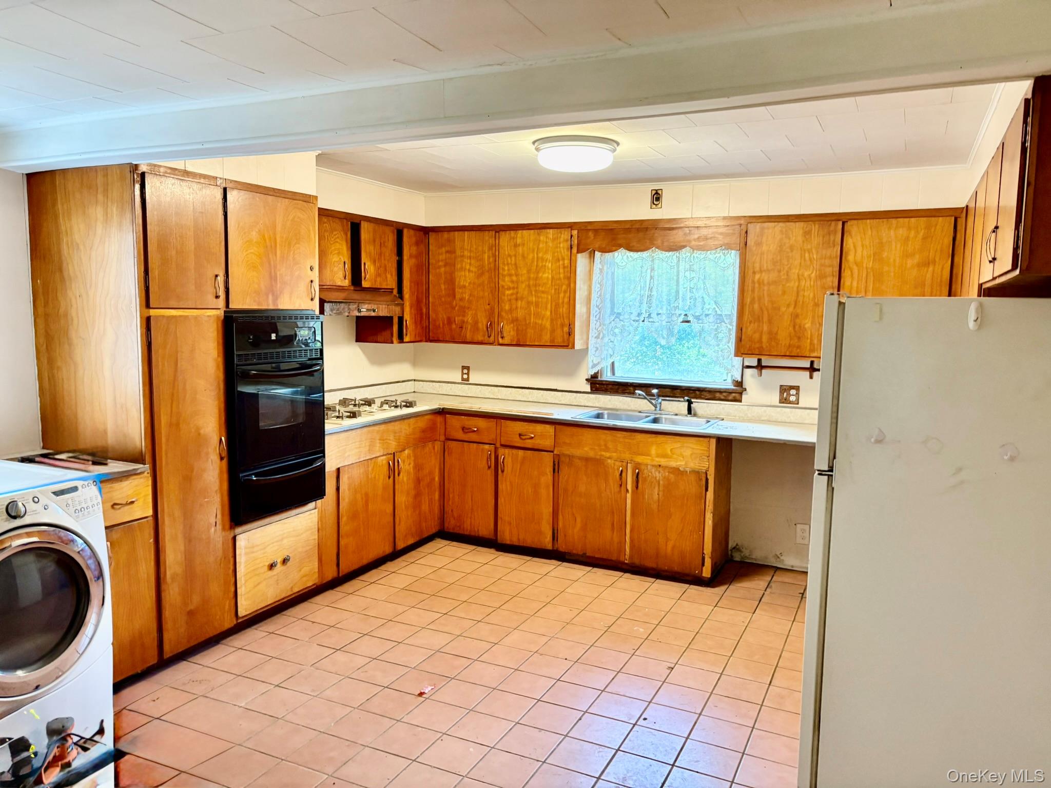 476 Old Rte 17 Livingston Manor, NY 12758 - Photo 6 of 39 Kitchen with white appliances, washer / clothes dryer, brown cabinets, light countertops, and a warming drawer