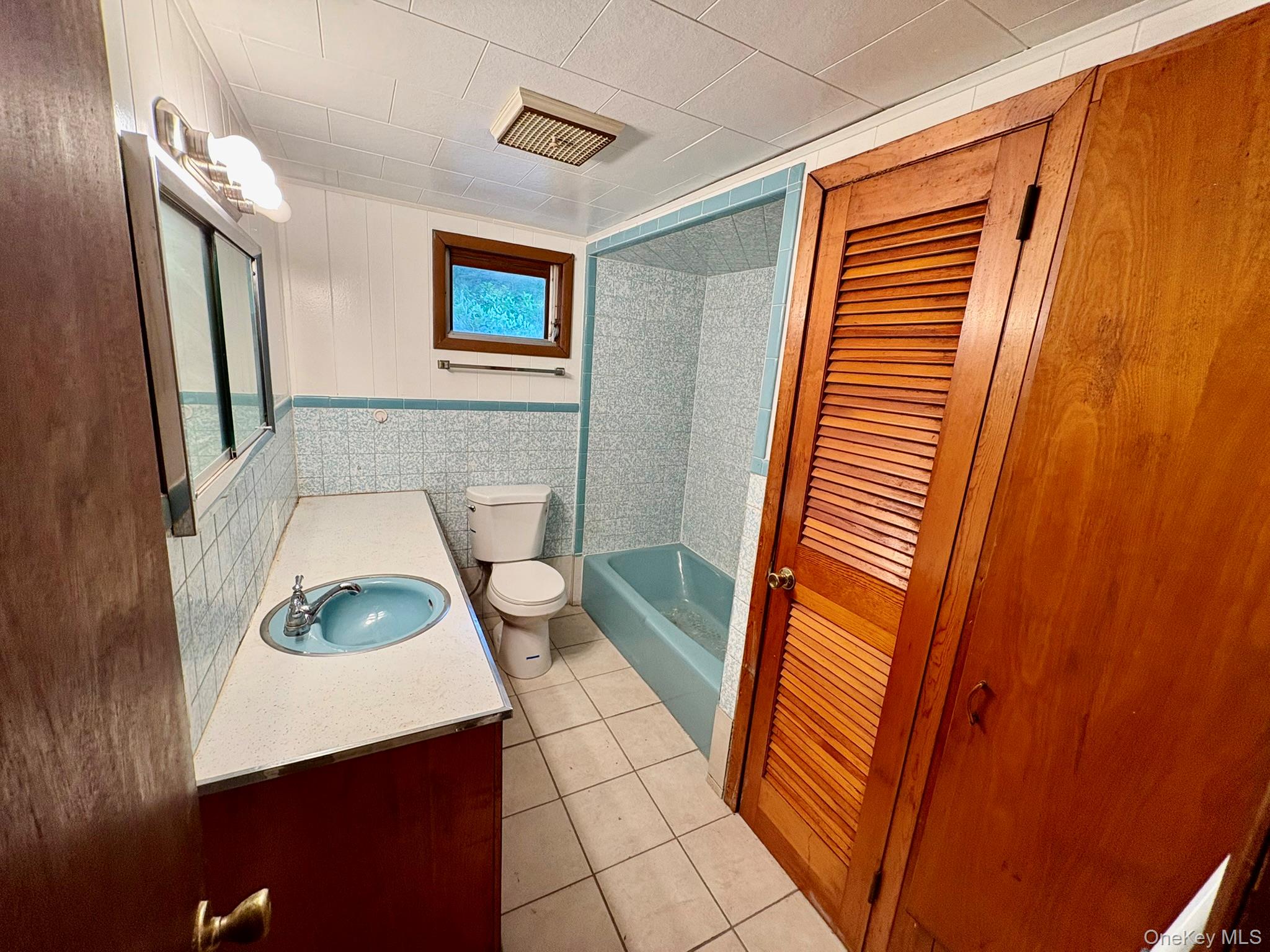 476 Old Rte 17 Livingston Manor, NY 12758 - Photo 7 of 39 Full bath with vanity, tile patterned floors, shower / bath combination, and tile walls
