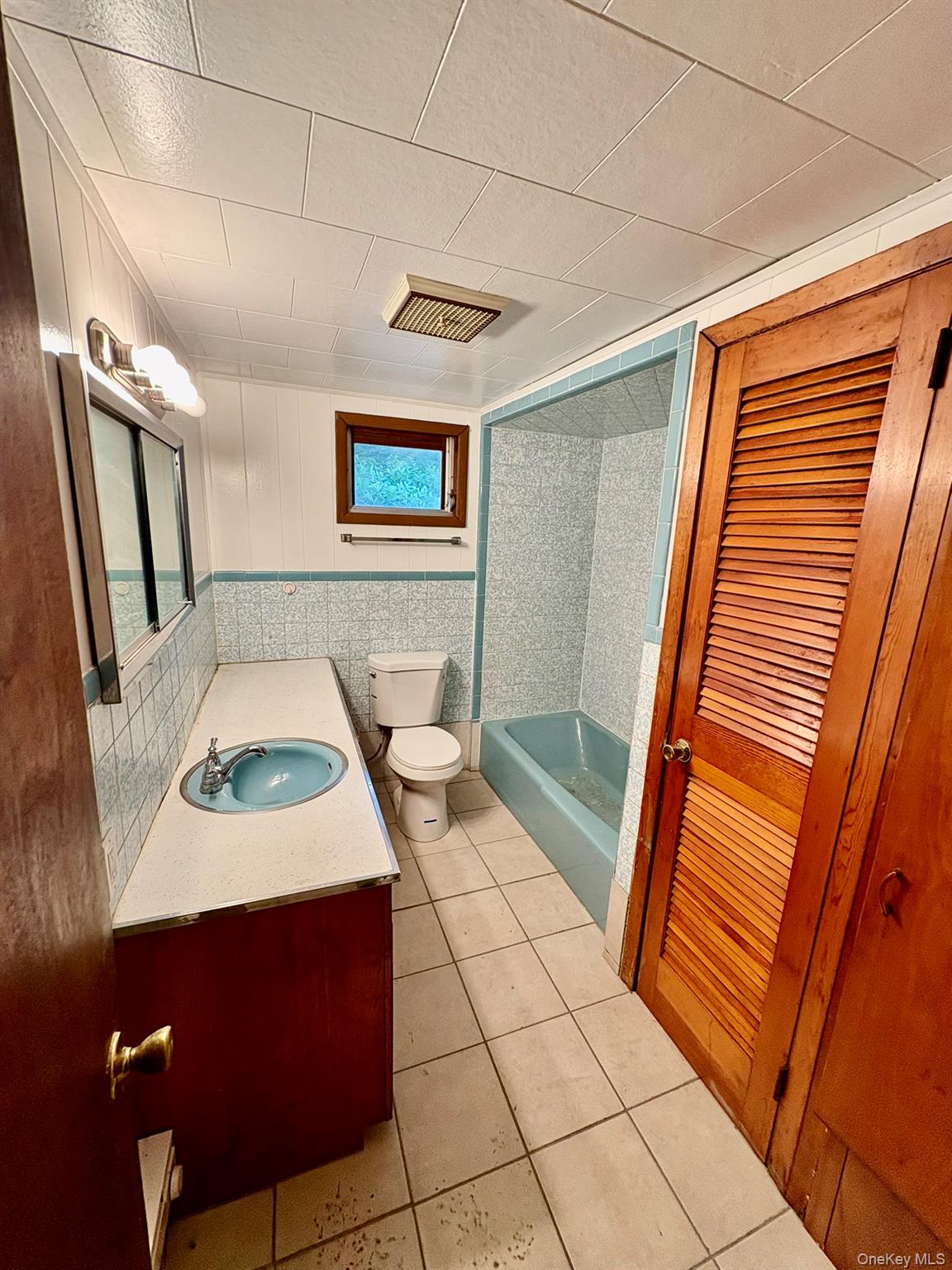 476 Old Rte 17 Livingston Manor, NY 12758 - Photo 8 of 39 Full bathroom with vanity, tile patterned flooring, shower / tub combination, and wainscoting