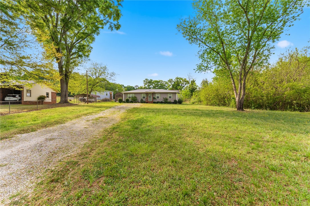 104 Leah Drive Pendleton, SC 29670 - Photo 2 of 23 This charming residence offers a peaceful retreat amidst natural surroundings, featuring a spacious yard.