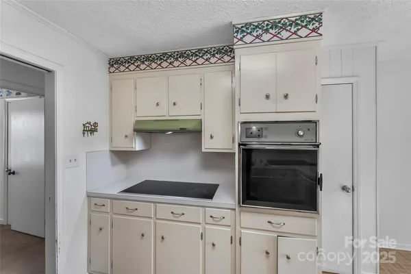 a kitchen with white cabinets and appliances
