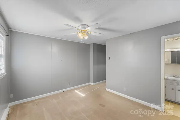 an empty room with closet and a ceiling fan