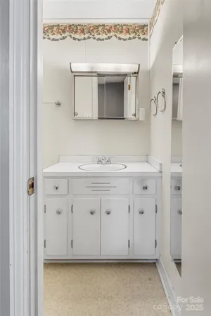 a bathroom with a sink vanity and mirror