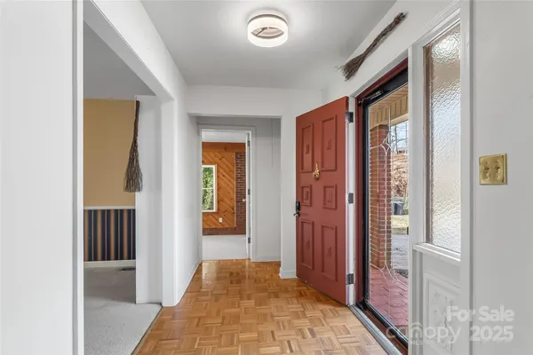 a view of a hallway with bathroom and wooden floor