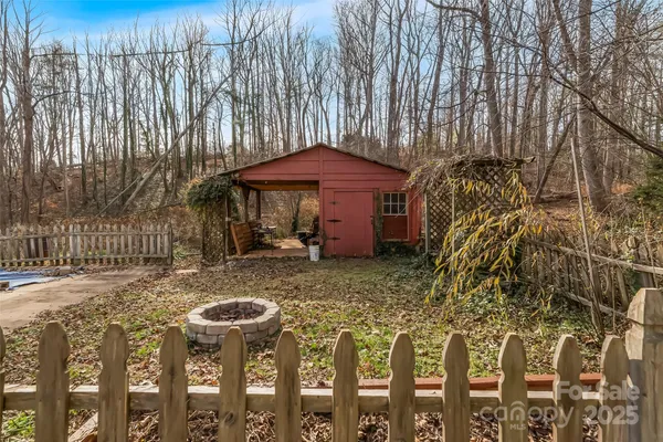 a view of a wooden house with a yard and furniture