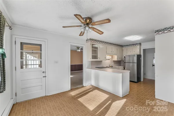 a living room with stainless steel appliances kitchen island furniture and a window