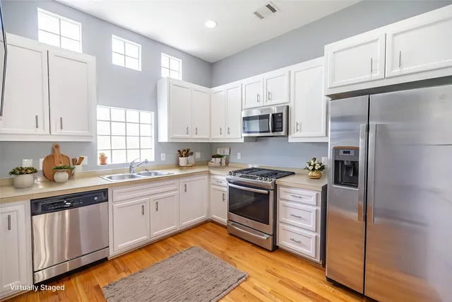 a kitchen with stainless steel appliances granite countertop a stove a sink and a refrigerator