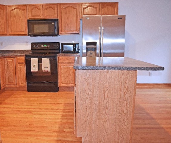 626 South Peace Road Sycamore, IL 60178 - Photo 4 of 24 a kitchen with stainless steel appliances granite countertop a stove a microwave and a refrigerator