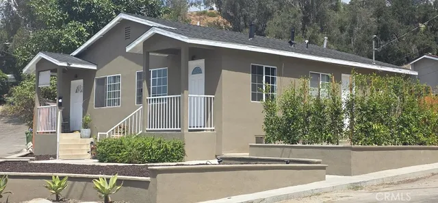 a front view of a house with a yard and potted plants