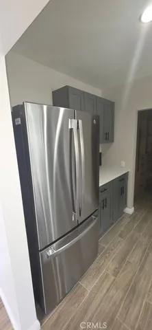 a view of a refrigerator in kitchen and an empty room
