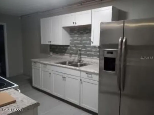 a kitchen with stainless steel appliances granite countertop a refrigerator and a sink