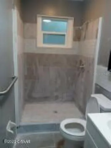 a bathroom with a toilet and a shower