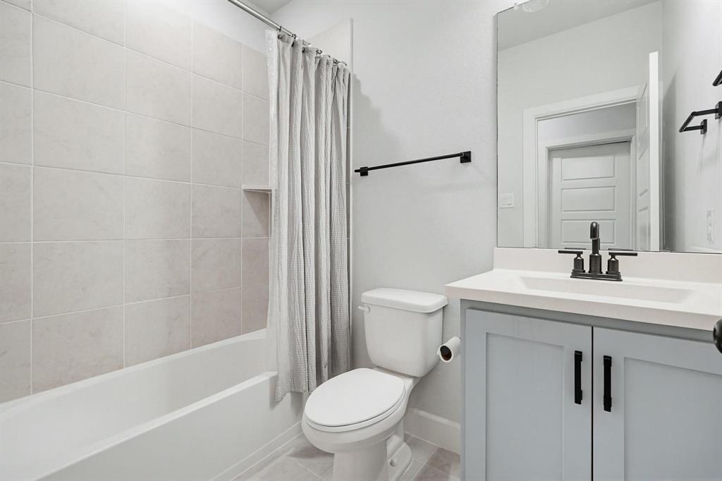 9341 Loggerhead Way Fort Worth, TX 76118 - Photo 28 of 35 Full bathroom featuring a single vanity with a light blue shaker-style cabinet, a white countertop, and a rectangular sink