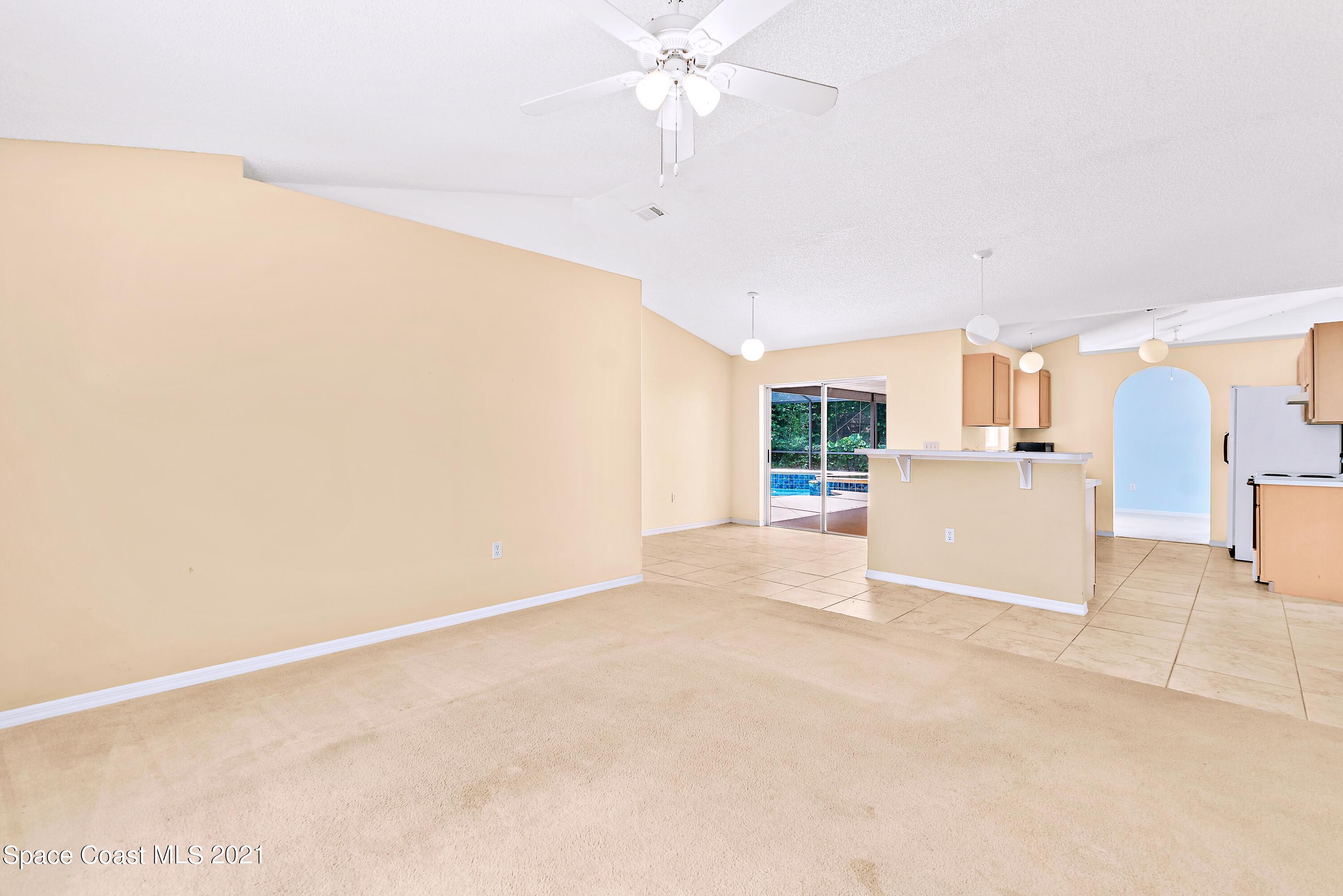 7250 Camilo Road Cocoa, FL 32927 - Photo 13 of 45 a view of a kitchen with wooden floor and a ceiling fan