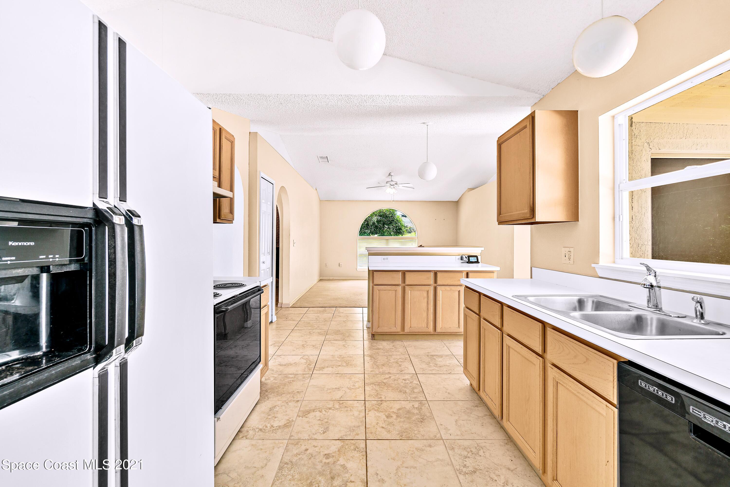7250 Camilo Road Cocoa, FL 32927 - Photo 15 of 45 a kitchen with stainless steel appliances a sink stove and cabinets