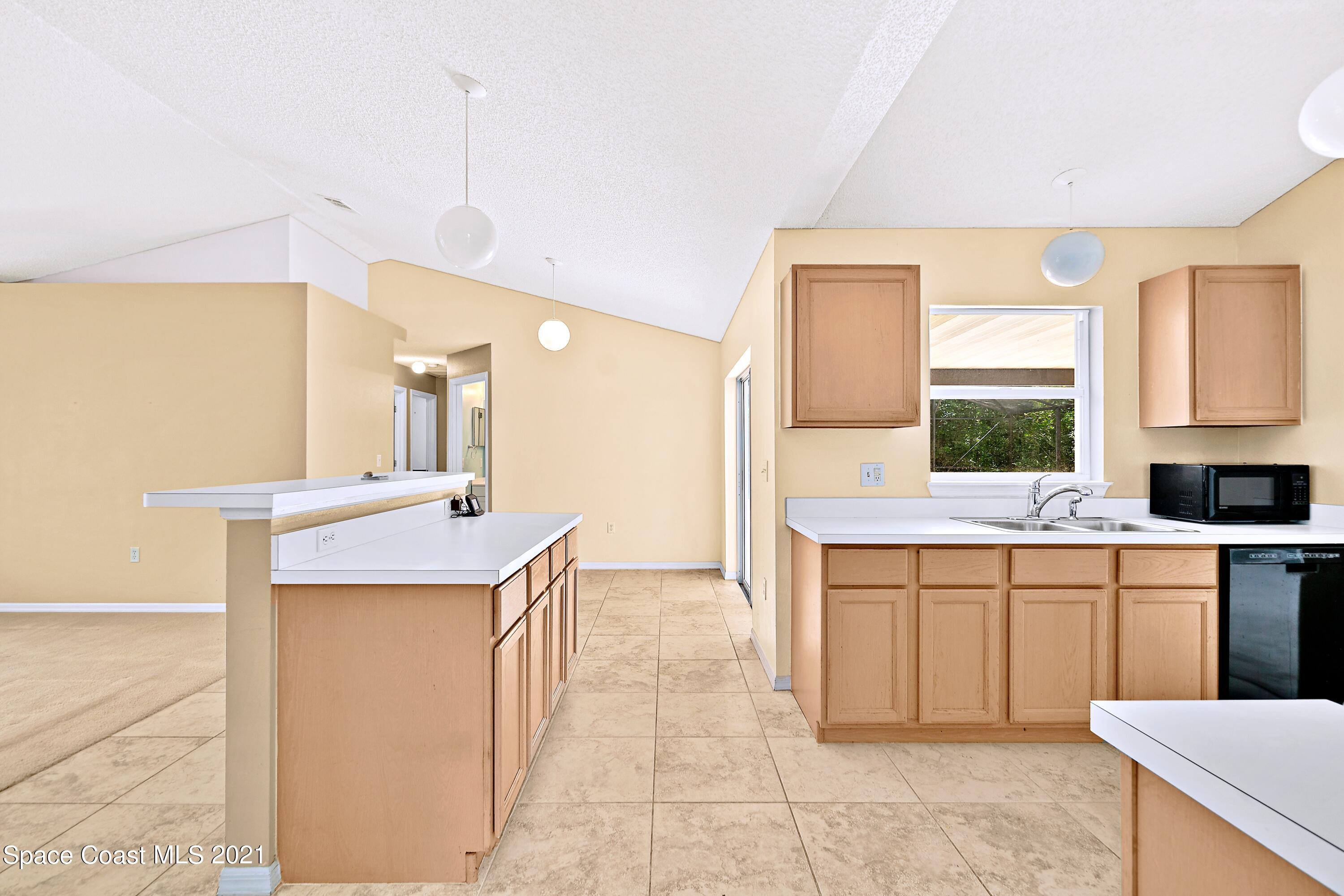 7250 Camilo Road Cocoa, FL 32927 - Photo 16 of 45 a kitchen with kitchen island a sink a counter top space and cabinets