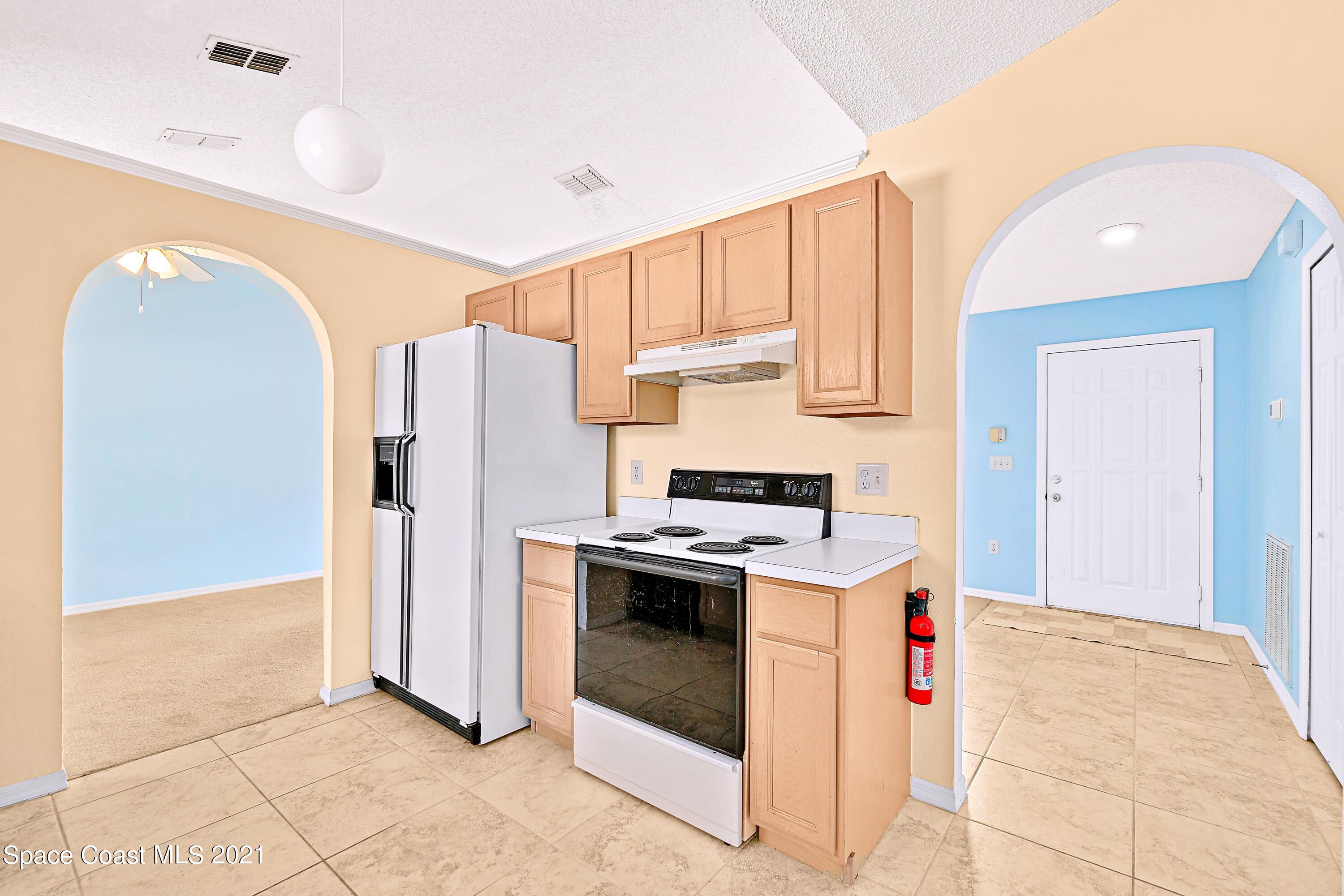 7250 Camilo Road Cocoa, FL 32927 - Photo 18 of 45 a kitchen with stainless steel appliances granite countertop a refrigerator a stove and a sink