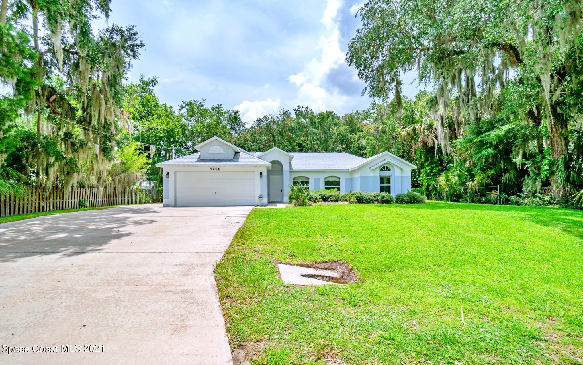 7250 Camilo Road Cocoa, FL 32927 - Photo 3 of 45 a aerial view of a house with a yard and large trees