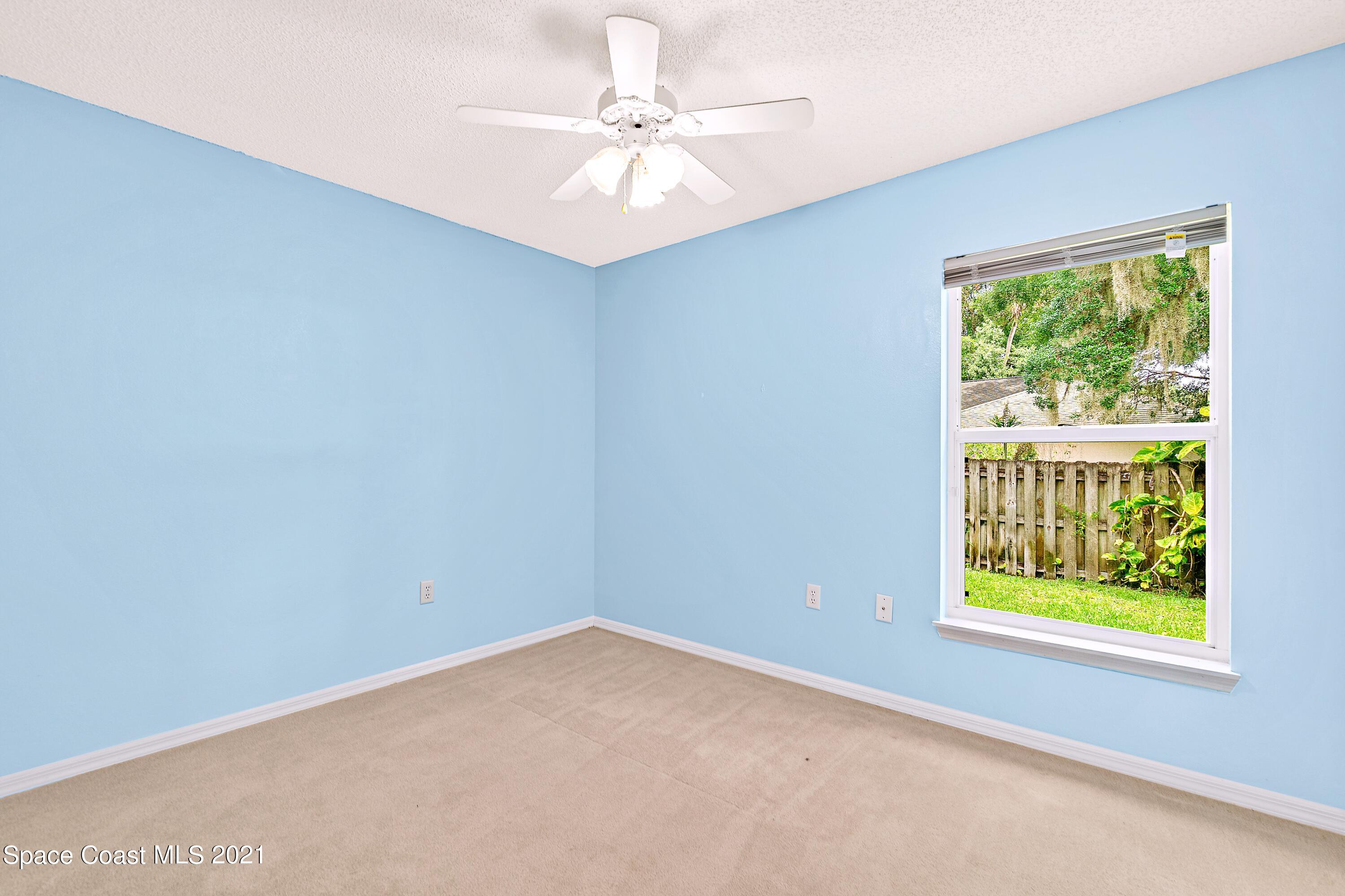 7250 Camilo Road Cocoa, FL 32927 - Photo 26 of 45 an empty room with windows and ceiling fan