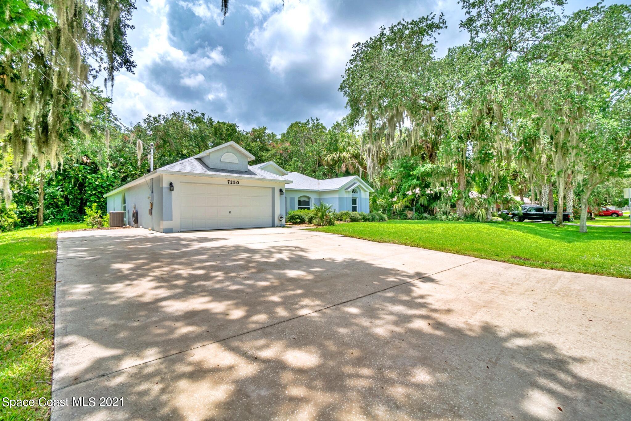 7250 Camilo Road Cocoa, FL 32927 - Photo 4 of 45 a front view of a house with a garden and yard