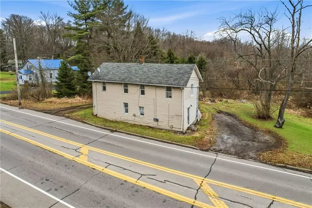 a view of a house with a fence and a forest