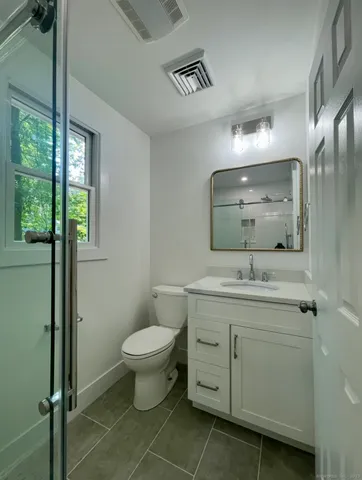 a bathroom with a toilet sink and mirror