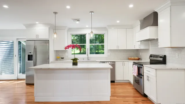 a kitchen with stainless steel appliances kitchen island granite countertop a sink a stove and a refrigerator